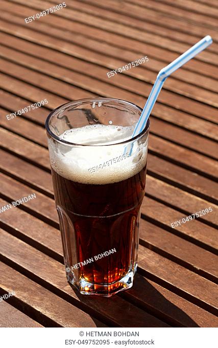 Cocktail with straw on the wooden table