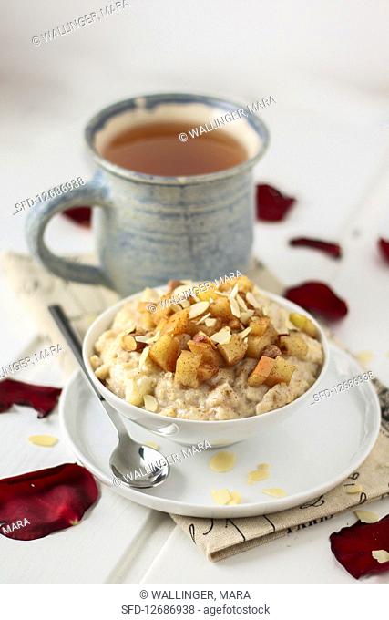 Apple cinnamon porridge with almond flakes and cup of tea