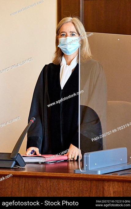 07 July 2020, Hamburg: Anne Meier-Göring, presiding judge, stands with a mouth guard between plexiglass walls in the courtroom before the trial begins