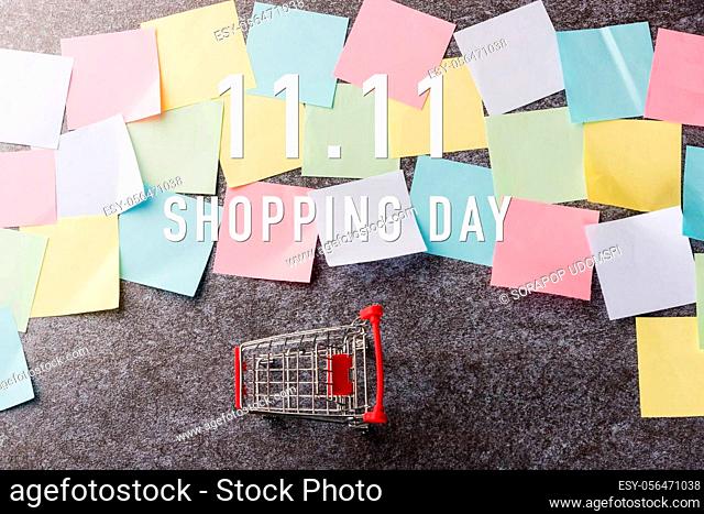Above blank paper stick note list yellow and green with the shopping cart with 11.11 single's day text on paper on concrete table background