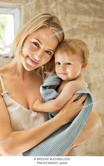 Woman holding her baby in towel
