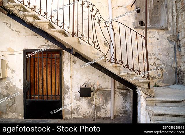 Traditional stair entrance with broken handle and door of Lebanese house in Tyre, Lebanon