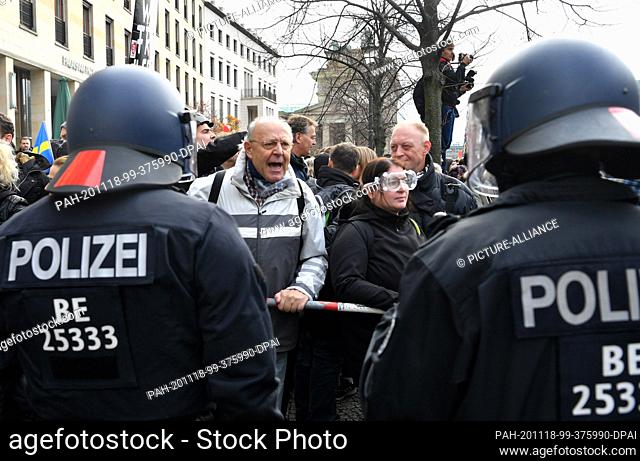 18 November 2020, Berlin: Participants of a demonstration against the Corona restrictions of the German government and police officers face each other between...