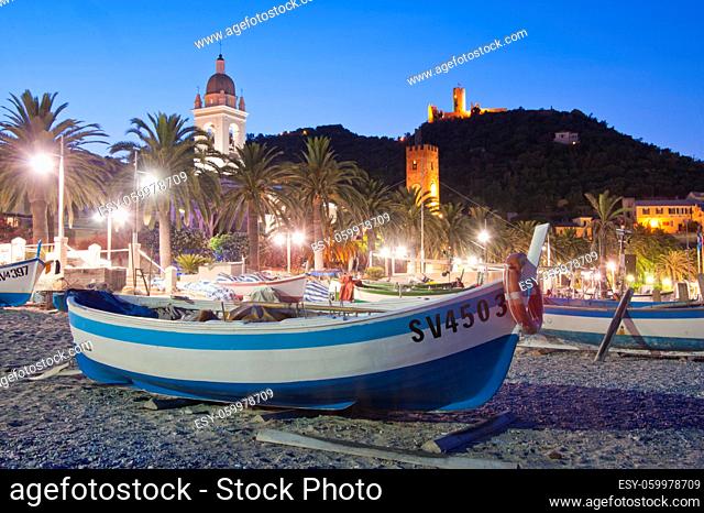 Boat on the cobblestones beach of Noli, facing the village of Noli, during the sunset