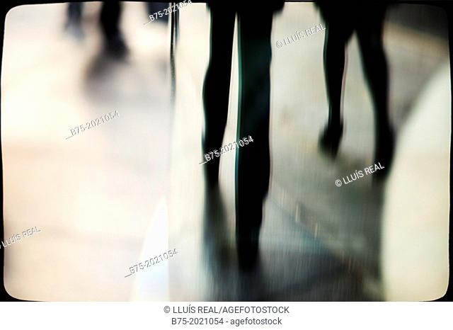 reflection in a glass of people legs walking down the street