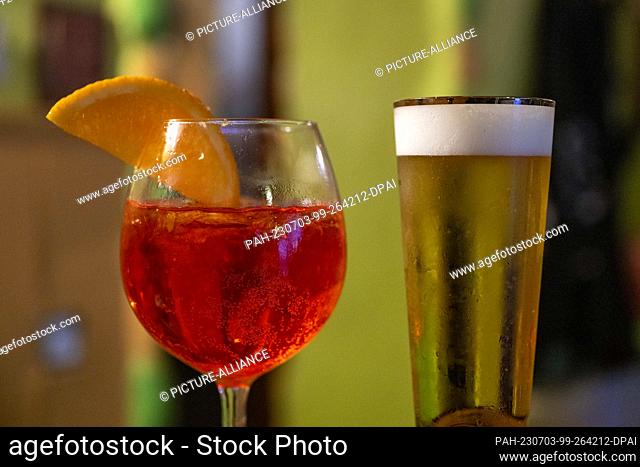 PRODUCTION - 01 July 2023, Berlin: In a bar, a glass of Aperol Spritz and a glass of non-alcoholic beer sit on a counter. Photo: Christophe Gateau/dpa