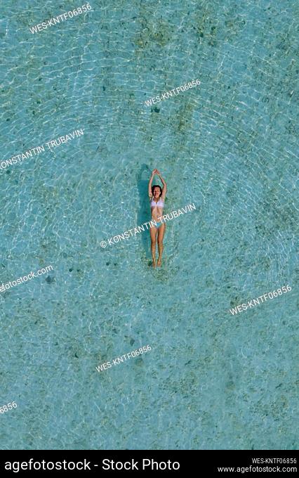 Drone view of woman swimming in turquoise sea