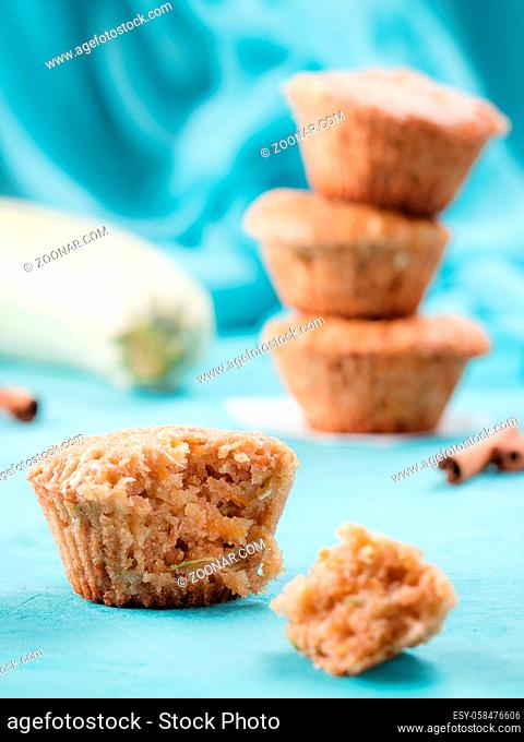 Close up view of muffin with zucchini, carrots, apple and cinnamon on blue concrete background. Sweet vegetables homemade muffins