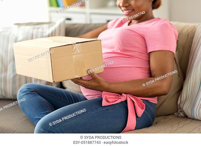 happy pregnant woman with parcel box at home