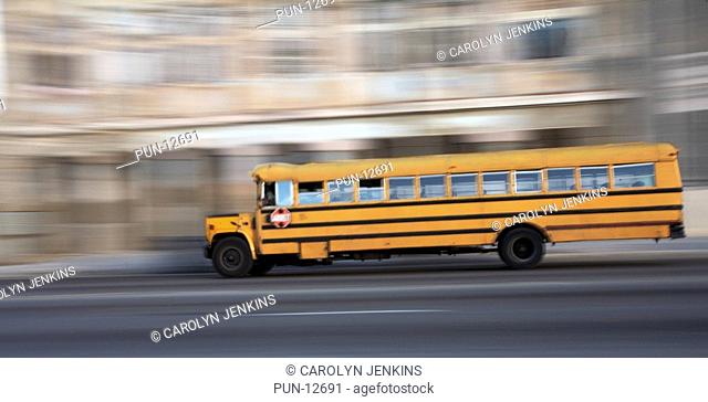 Yellow bus speeding along the road at Havana, Cuba, West Indies, Caribbean, Central America