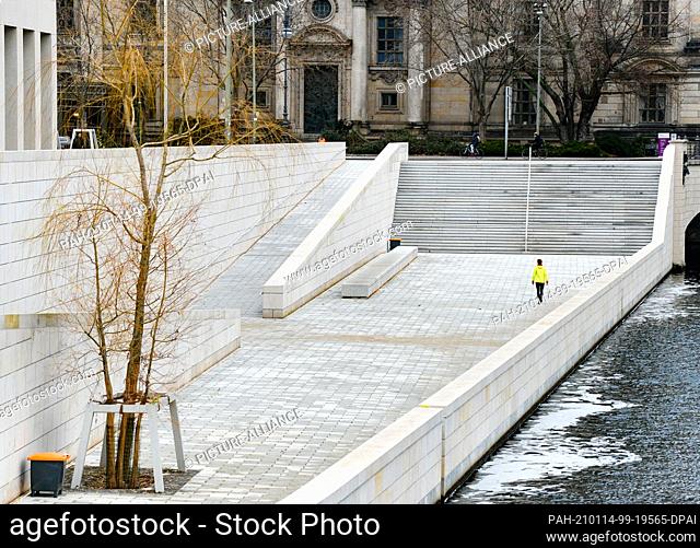 13 January 2021, Berlin: Only one jogger is walking on a newly designed area between the Humboldt Forum and the banks of the Spree