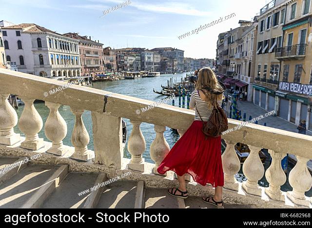 Young woman with red skirt photographed, bridge on the Grand Canal, Rialto Bridge, Venice, Veneto, Italy, Europe
