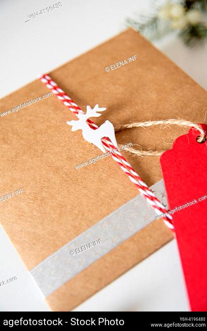 Charming rustic holiday wrapping featuring a reindeer motif and red twine, set against the warmth of craft paperâ. ”a perfect blend of tradition and elegance