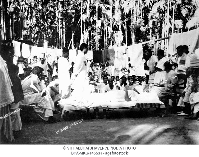 Mahatma Gandhi , while resting , talking to people in Noakhali East Bengal riots between Hindus and Muslims