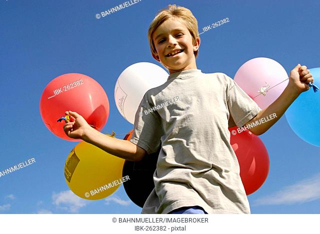 Boy runs with ballons