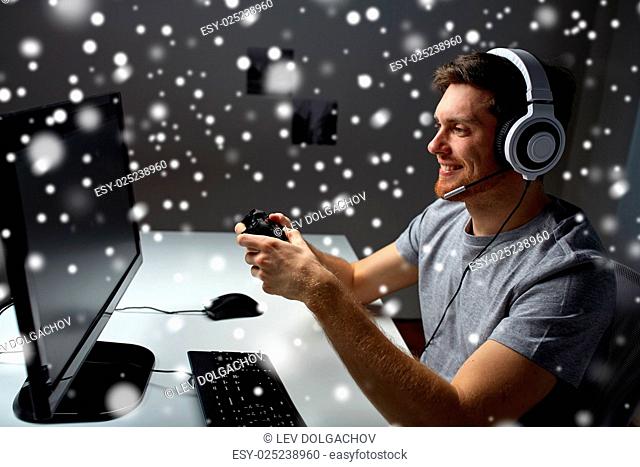 technology, gaming, entertainment, let's play and people concept - young man in headset with controller gamepad playing computer game at home and streaming...