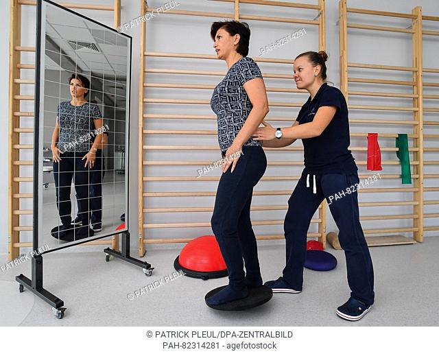 A therapist (R) exercises with a patient in the rehab section of brandmed, a cross-border health center in the Polish city Slubice