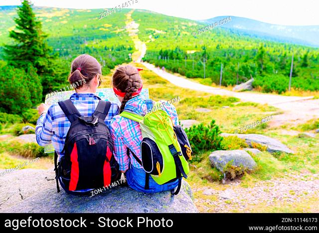 Mother and Daughter Traveler with map backpacks relaxing outdoor with mountains on background Summer vacations and Lifestyle hiking concept