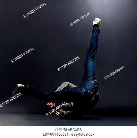 Portrait of a young male breakdancer showing his dancing skills against grunge background