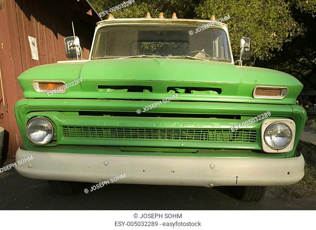Bright green 1950s truck parked in front of red barn in Oak View, California