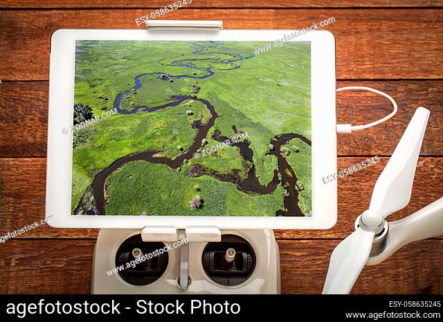 Illinois River meanders through Arapaho National Wildlife Refuge, North Park near Walden, Colorado in early summer, reviewing an aerial image on a digital...