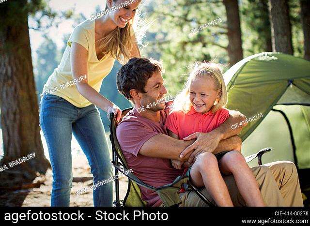 Smiling family at campsite in woods