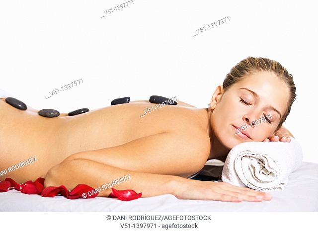 Blonde woman in massage with stones und petals