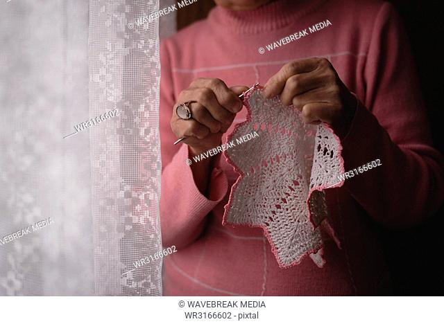 Senior woman knitting wool at home