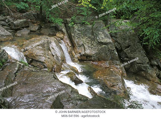 Water flows over rain soaked rocks in a stream in New Hampshire, United States
