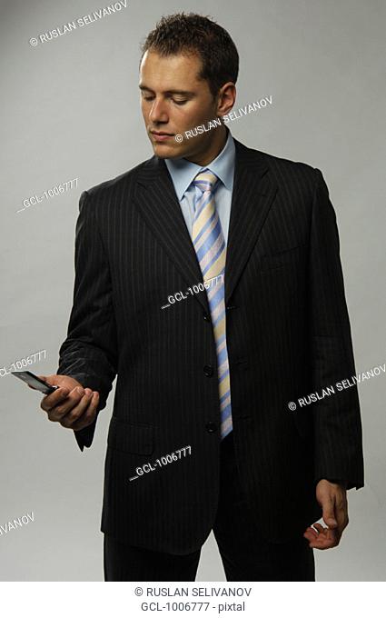 Earnest businessman looking at his mobile phone