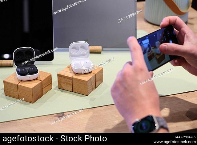 RUSSIA, MOSCOW - OCTUBRE 4, 2023: Un hombre toma fotos de Samsung Earbuds durante una presentación de los nuevos productos de Samsung en una tienda de MTS