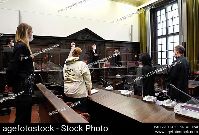13 January 2022, Hamburg: The defendant (front, 2nd from left) stands in the courtroom in the Criminal Justice Building at the beginning of the trial for...