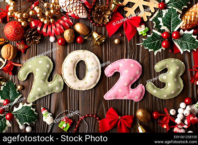 Colorful stitched digits 2022 of polkadot fabric with Christmas decorations flat lay background on wooden table