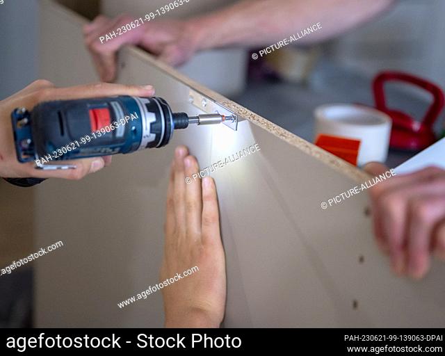 19 June 2023, Berlin: A craftsman screws a screw into a clamping plate with a cordless screwdriver. Photo: Monika Skolimowska/dpa