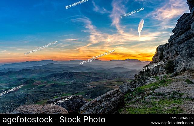 A landscape view of the el Torcal rock formations and the Montes de Malaga Nature Park in Andalusia at sunset