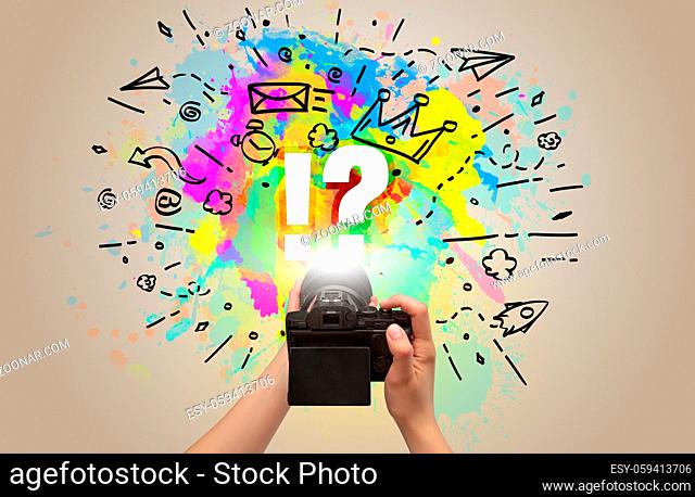 Close-up of a hand holding digital camera with abstract drawing and !? inscription
