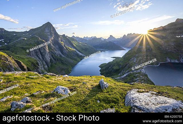 Sun shining over mountain landscape with fjord Forsfjorden and lake Krokvatnet, Moskenesöy, Lofoten, Nordland, Norway, Europe