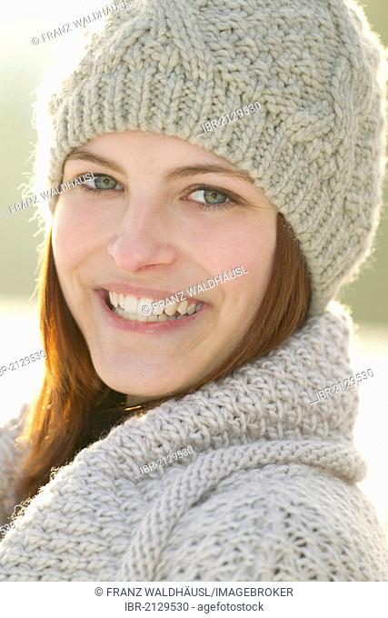 Young woman wearing a cardigan and a woolen hat
