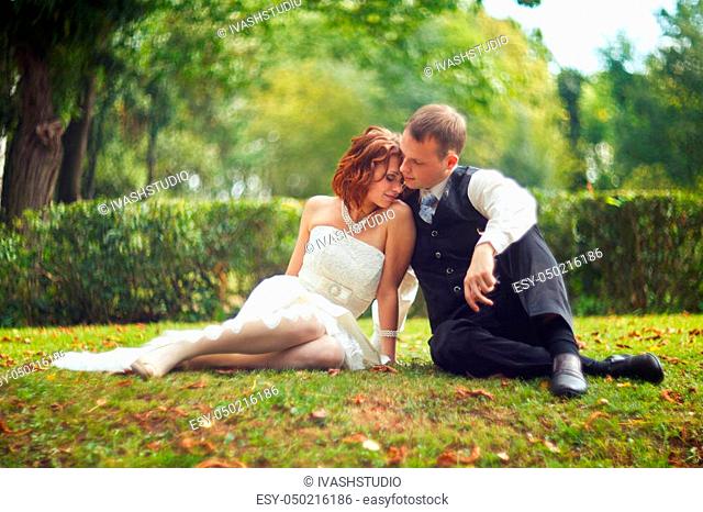 Trust and hug - wedding couple rests on the green ground