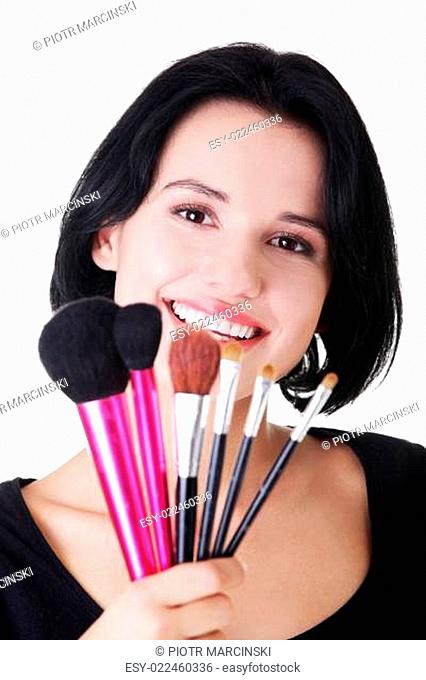 Young make-up artist woman holding brushes