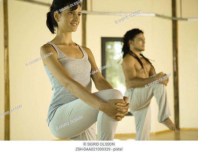 Yoga class standing, holding knees