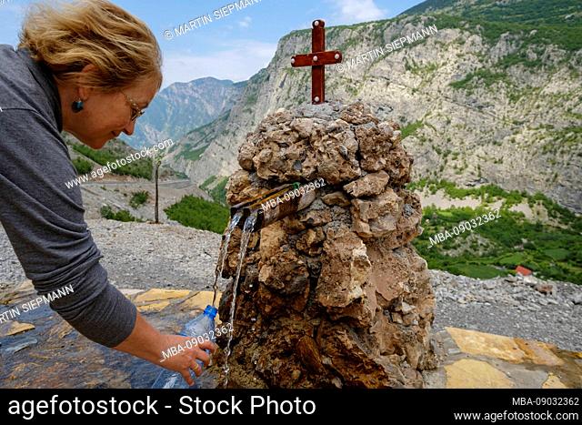 Woman fills in water from a confined source at Selca, Kelmend region, Albanian Alps, Prokletije, Qark Shkodra, Albania