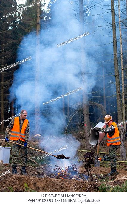 28 October 2019, Saxony-Anhalt, Straßberg: Soldiers of the Logistics Battalion 171 from Burg burn the bark of the spruces infested by the bark beetle on a...
