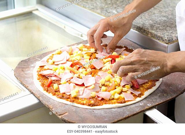Close up chef baker making pizza at kitchen