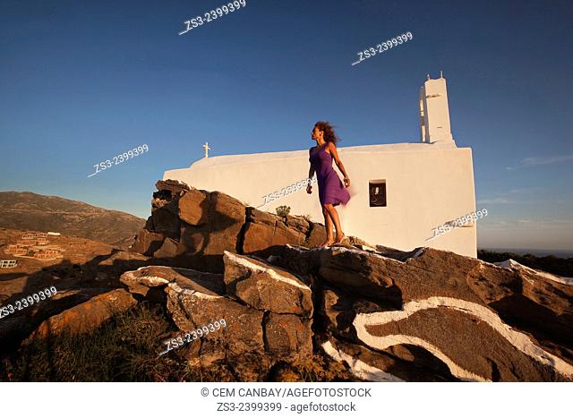 Woman standing in front of a chapel at the top of the hill in Chora, Ios, Cyclades Islands, Greek Islands, Greece, Europe