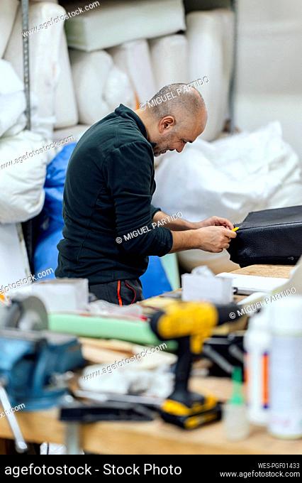 Craftsman repairing in upholstery workshop