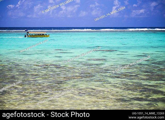 Tourist boat trip on a summer vacation to the tropical island of Rarotonga in the perfect crystal clear blue water of Muri Lagoon, Pacific Ocean