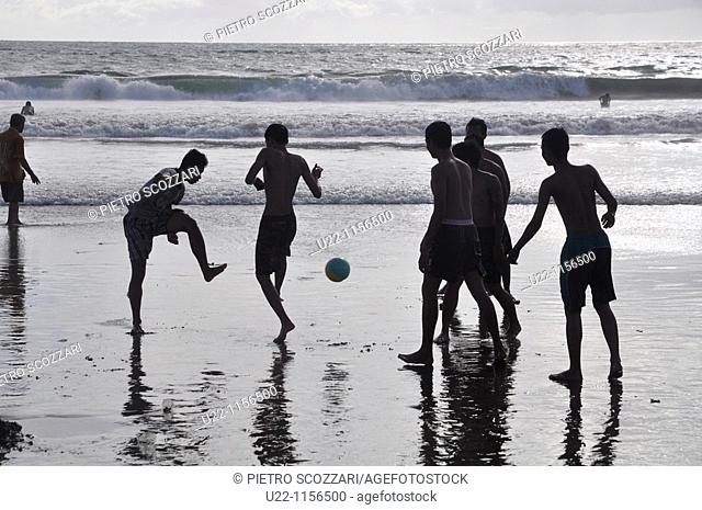 Kuta Beach (Bali, Indonesia): some youngsters playing soccer on the shore at sunset