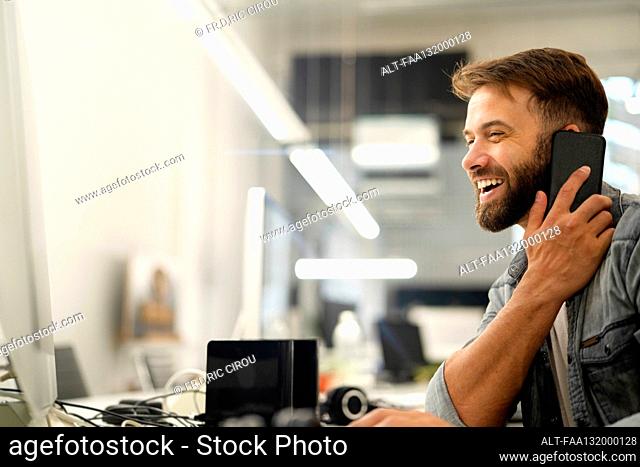 System engineer laughing while talking on smart phone