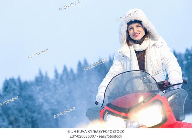 Winter, beautiful woman and a snowmobile, horizon format